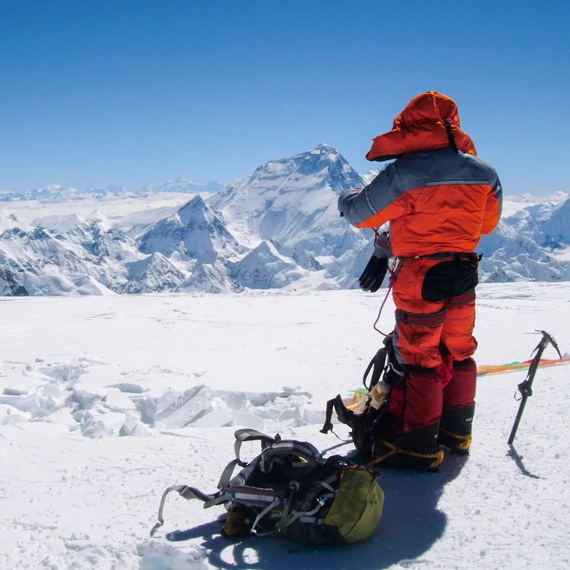 Kamil in a high-altitude summit suit looking out over the Himalaya toward Everest